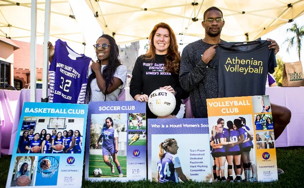 Three people holding up T-shirts and smiling behind four posters advertising MSMU Sports clubs