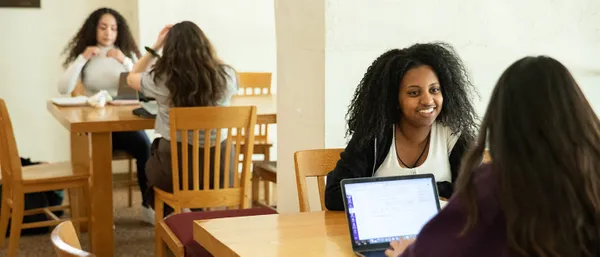 Students sitting at tables and talking.
