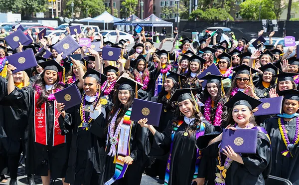 Students showing their diplomas at Commencement 2022