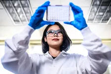Student holding wells plate