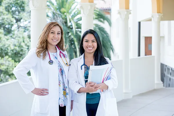 Two nursing students wearing white coats