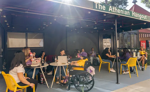 Students sitting around round tables outdoors