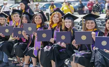 Group of students showing their diplomas at 2022 Commencement.