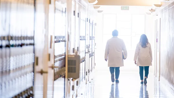 two nursing students walking away down a hall with bright exposure