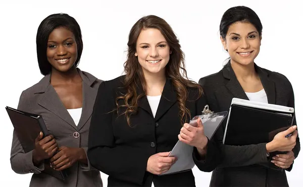 three female diverse students in business attire smiling holding notebooks