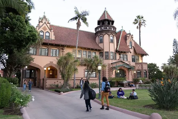 Doheny mansion with students walking in front yard