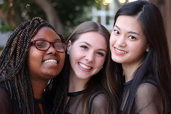 Three alumnae smiling