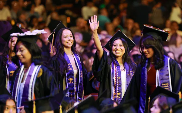 MSMU Graduates walking and waving in the commencement procession