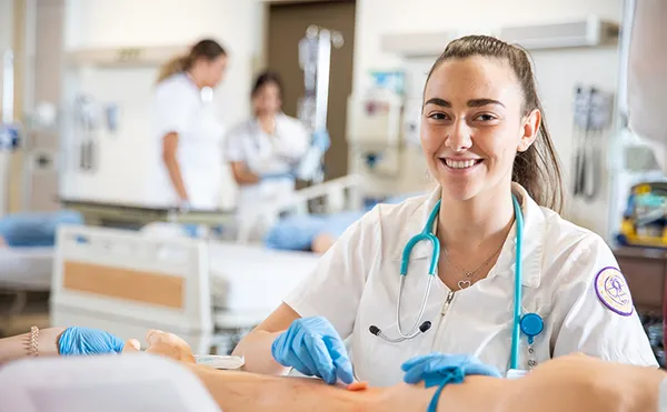 Nursing student practicing on arm