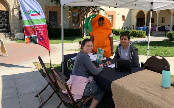 Three students around an MSMU Peer Wellness program event booth