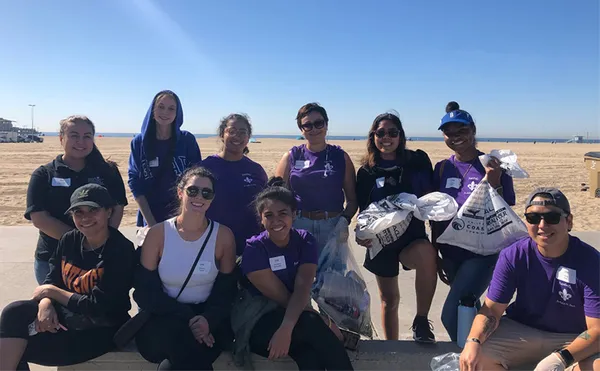 A group photo of students during a beach cleanup event.