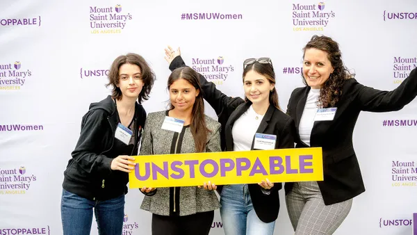 group of women posing in front of MSMU backdrop