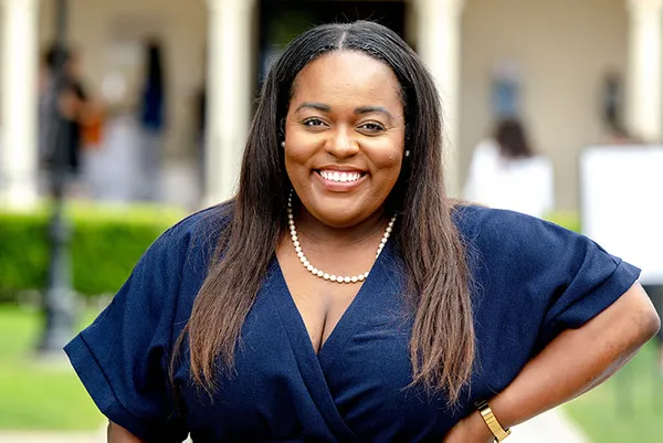woman in blue dress smiling into camera